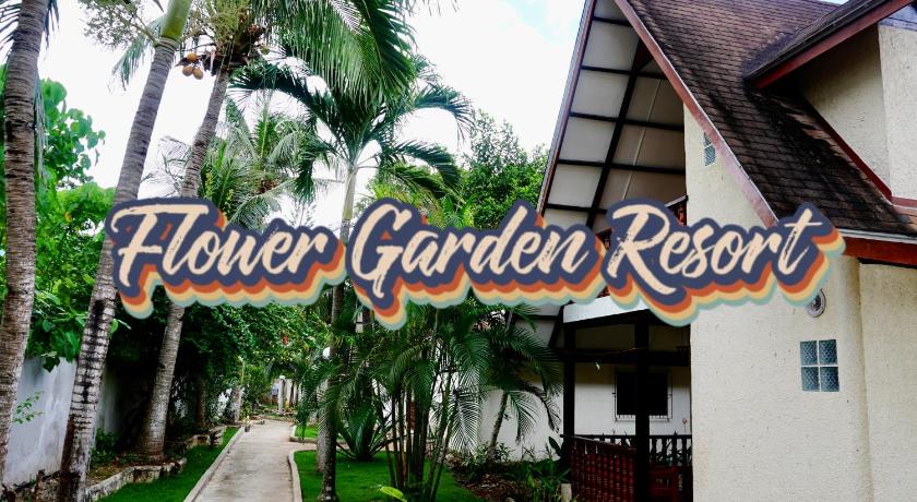 a sign on a building with palm trees, Flower Garden Resort in Bohol