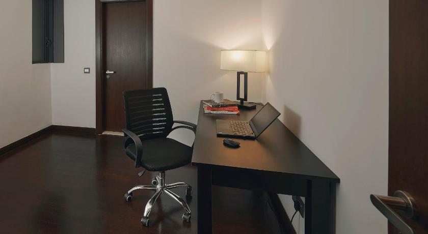 a desk with a chair and a lamp on it, TRILLION SUITES by SLG in Kuala Lumpur