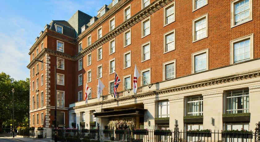a large brick building with a clock on the side of it, London Marriott Hotel Grosvenor Square in London