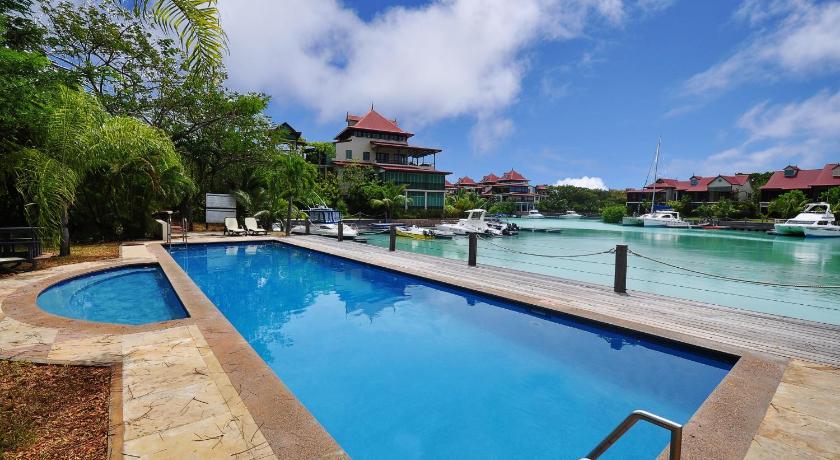 a large swimming pool in front of a large building, EDEN ISLAND/BEACH FRONT/LUXURY/3 BED ENSUITE/WIFI in Seychelles Islands