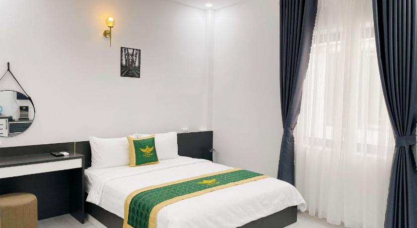 a hotel room with a bed and a nightstand, Le Phan Hotel in Tay Ninh