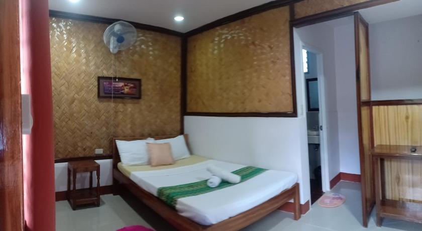 a bedroom with a large bed and a large window, Telesfora Beach Cottage in Palawan