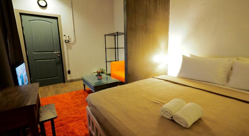 a hotel room with a bed and a television, Uno Chiangmai Guest House in Chiang Mai