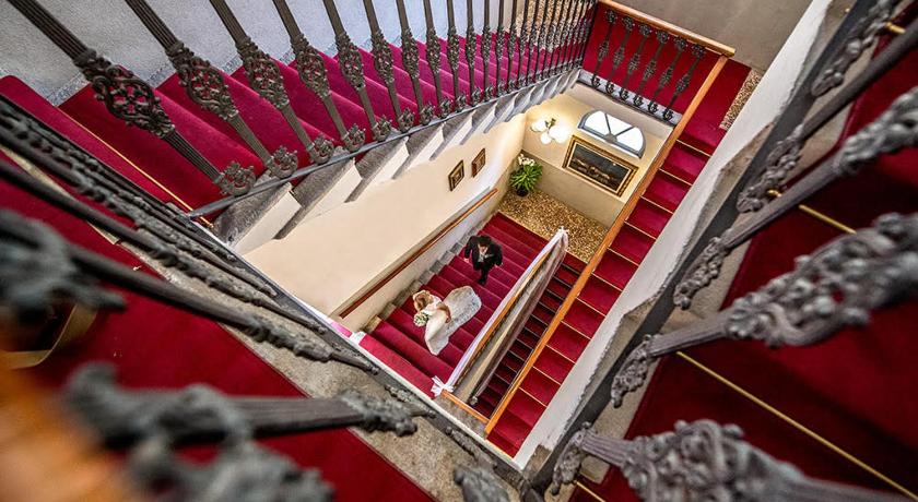 a staircase leading to a room with a large mirror, Hotel Villa Giulia in Valmadrera