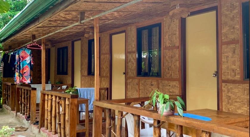 a wooden cabin with a wooden table and chairs, Domos Native Guest House in Bohol