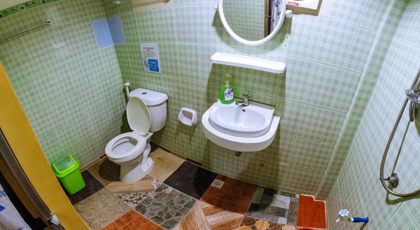 a bathroom with a toilet and a sink, APO PENSION HOUSE in Palawan