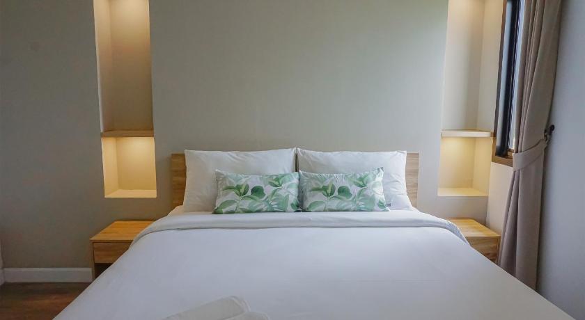 a white bed with a white comforter and pillows, Carnation Residence in Samut Prakan