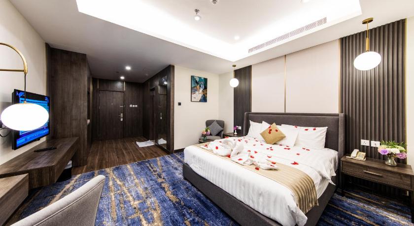 a hotel room with a bed and a television, Lily Hotel Suites Hfouf in Hofuf