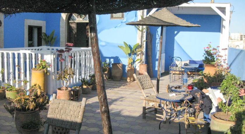 a patio area with chairs, tables and umbrellas, Riad Le Grand Large in Essaouira