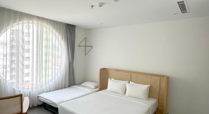 a bedroom with a white bed and white walls, Meander Saigon in Ho Chi Minh City