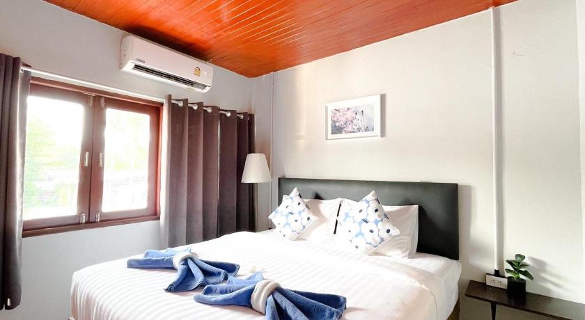 a bedroom with a bed and a window, MOOK BOONCHU HOTEL in Trang