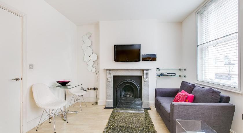 a living room filled with furniture and a fireplace, St Christopher's Place Serviced Apartments Central London in London
