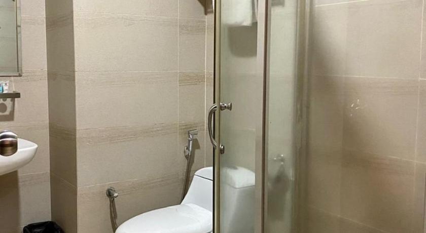 a bathroom with a toilet and a shower stall, My Inn Hotel in Lahad Datu