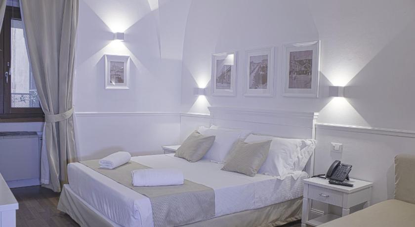 a hotel room with a white bed and white walls, Palazzo Sant'Elena in Foggia