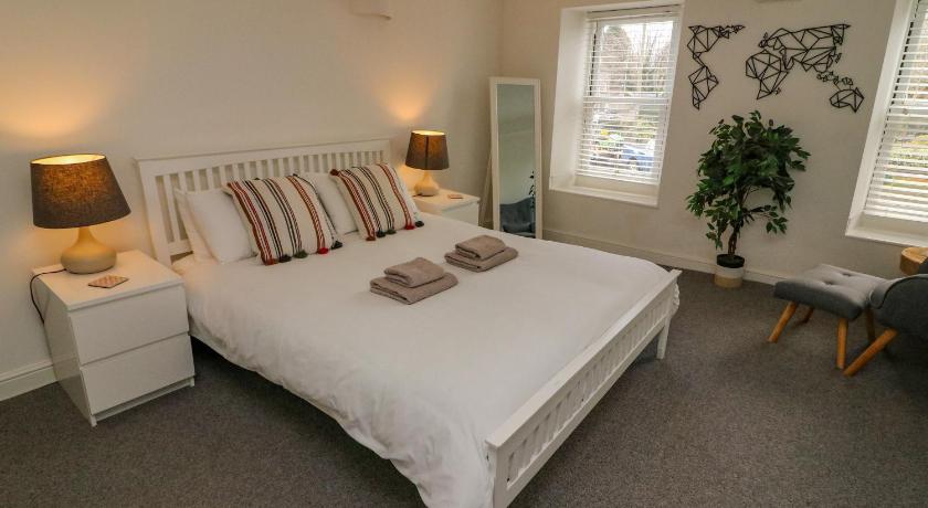 a white bed sitting in a bedroom next to a window, Bay Leaf Cottage, Kirkby Stephen in Brough