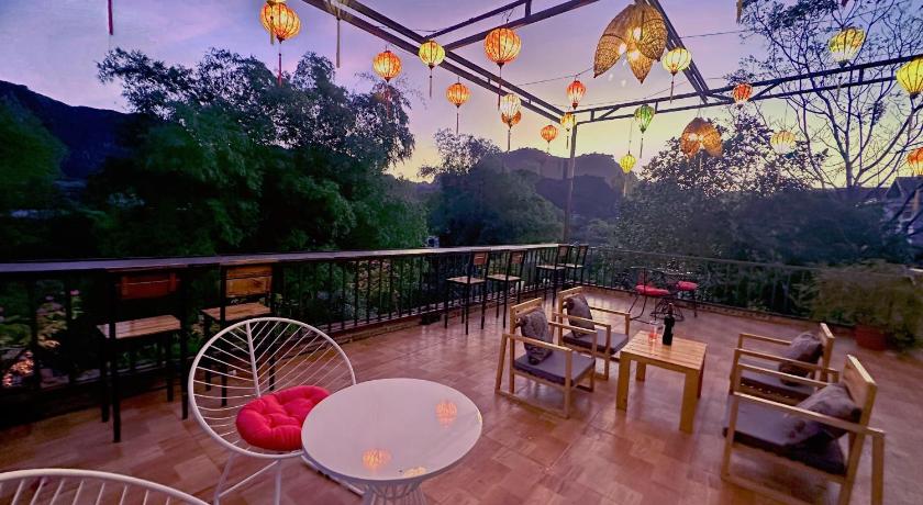 a patio area with tables, chairs and umbrellas, Trang an moon garden homestay in Ninh Bình