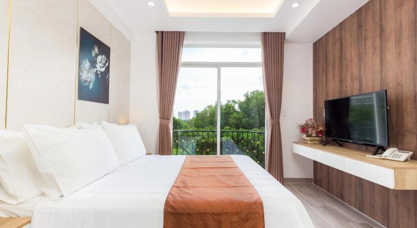 a bedroom with a large bed and a television, SAKI APARTHOTEL in Ho Chi Minh City