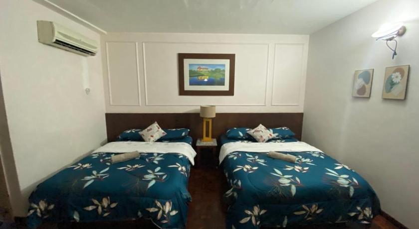 two beds in a room with a blue wall, D'Sofiya Homestay A Famosa Melaka in Malacca