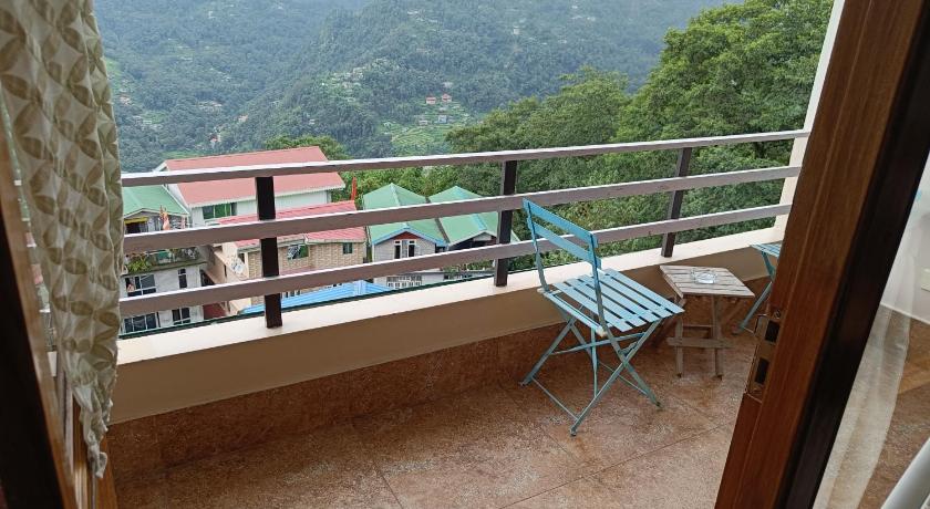 a wooden bench sitting in front of a balcony, Hotel 100 Petals Gangtok in Gangtok