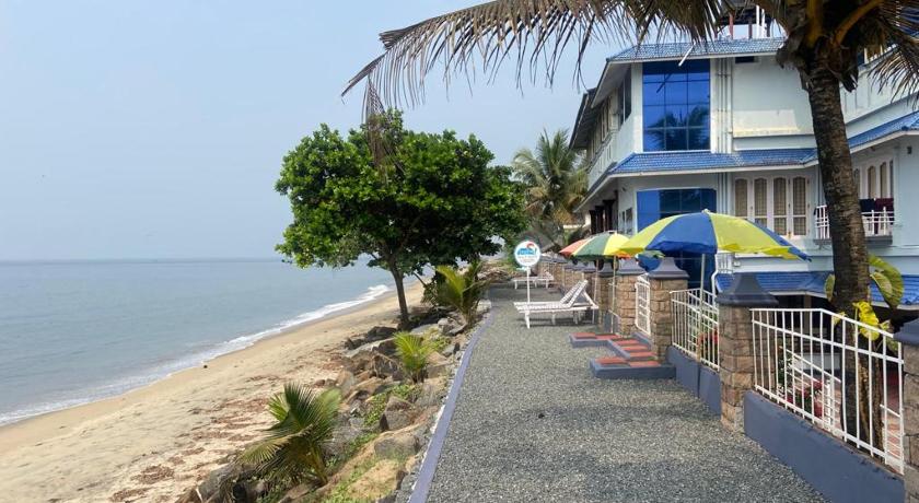 a beach with a beach house and a beach umbrella, Sealine Beach Resort in Kochi