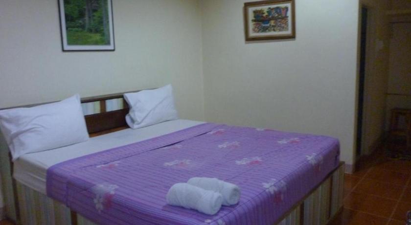 a bed that has a blue blanket on it, Baan Din Baramee Resort in Kamphaeng Phet