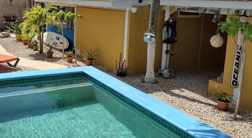 a pool with a pool table and a blue umbrella, Barefoot Bonaire in Kralendijk