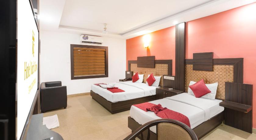 a hotel room with two beds and a television, Hotel Kochi Crown in Kochi