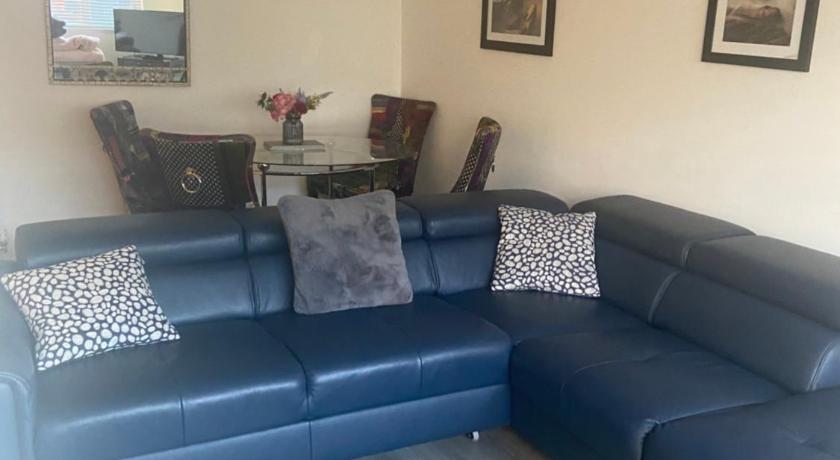 a living room filled with furniture and a blue couch, Bow Serviced Apartments in Glasgow
