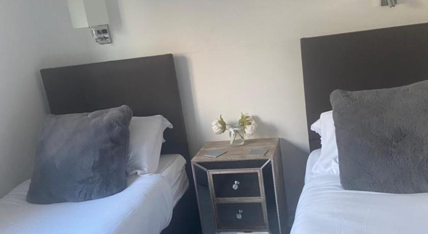 a hotel room with two beds and two nightstands, Bow Serviced Apartments in Glasgow
