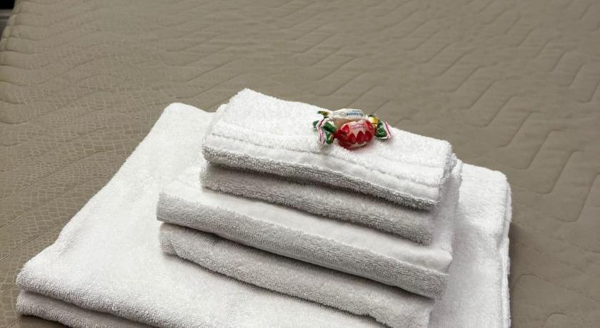 a white towel laying on top of a white pillow on top of a bed, VICTORIA HOTEL B&B in Naples