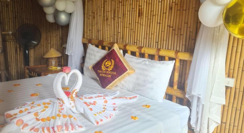a bed room with a large bed and a large window, Tam Coc Horizon Bungalow in Ninh Bình