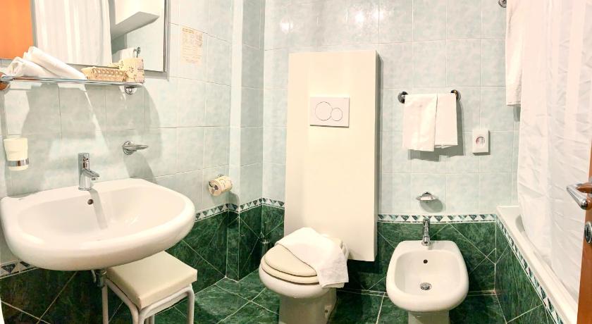 a white toilet sitting next to a sink in a bathroom, Hotel Raffaello in Urbino