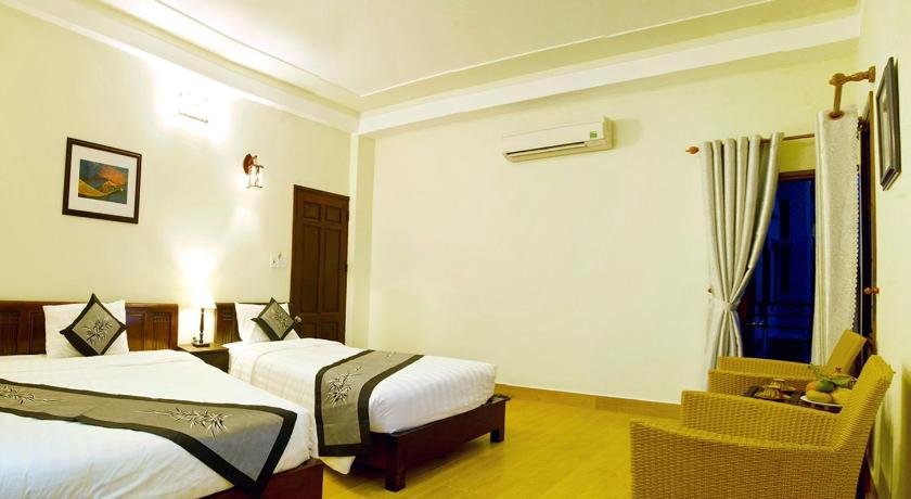 a hotel room with two beds and a television, An Hoi Town Homestay in Hoi An