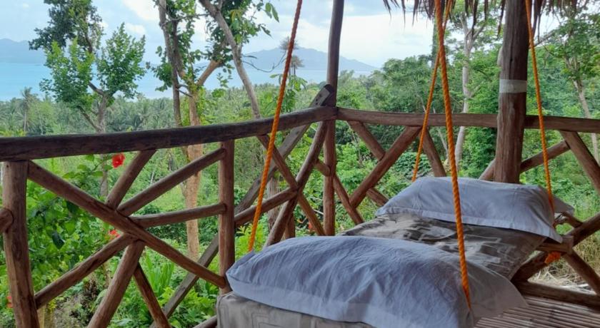a parasol is hanging from a wooden railing, Erlittop Garden Eco Lodge in Palawan