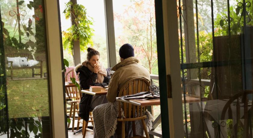 people sitting at a table in front of a window, Rustic Spirit Cottage in Blue Mountains