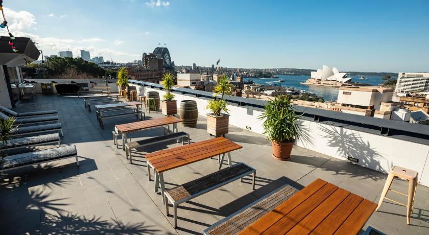 a patio area with chairs, tables and umbrellas, Sydney Harbour YHA in Sydney