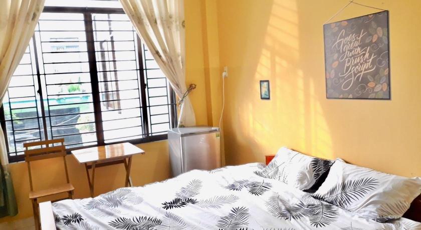 a bed sitting in front of a window next to a window, Stay House in Cần Thơ