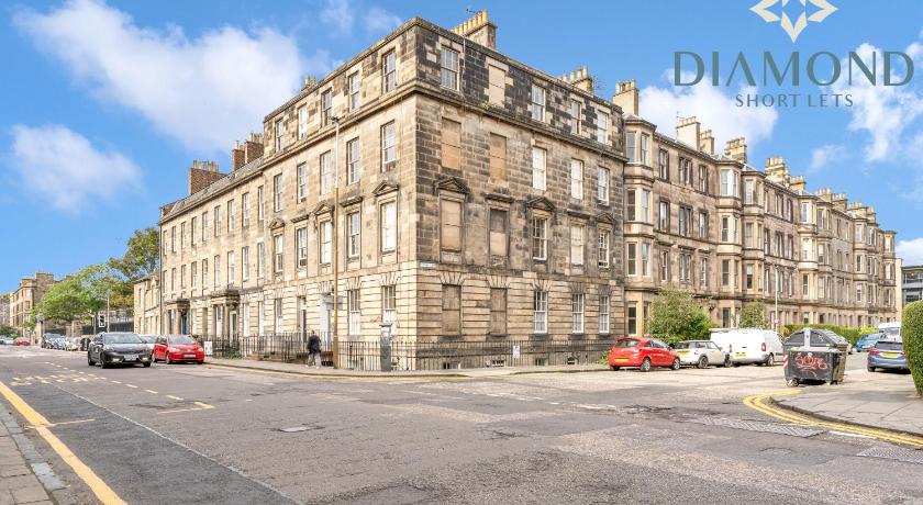 a large building with a clock on the side of it, Spacious 1 Bed Ground Floor Apartment with Garden in Edinburgh