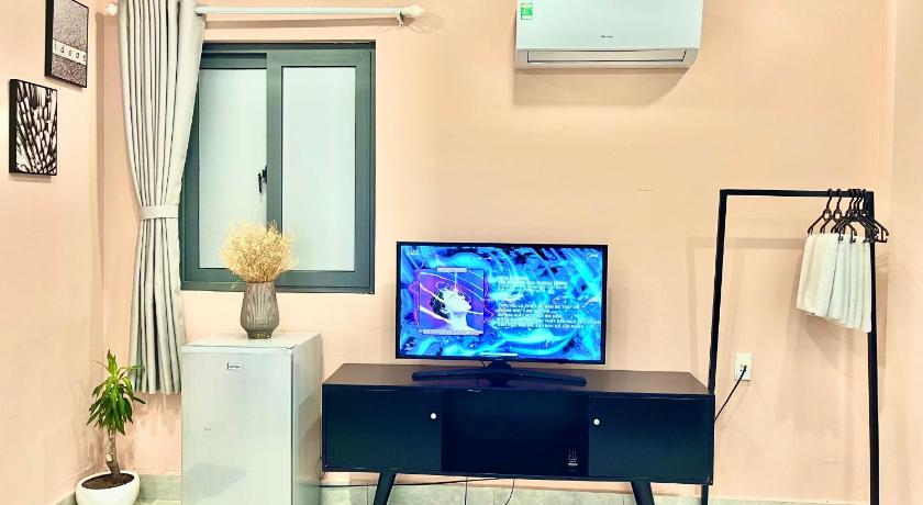 a living room with a flat screen tv on the wall, MIDMOST Boutique Hostel in Cần Thơ