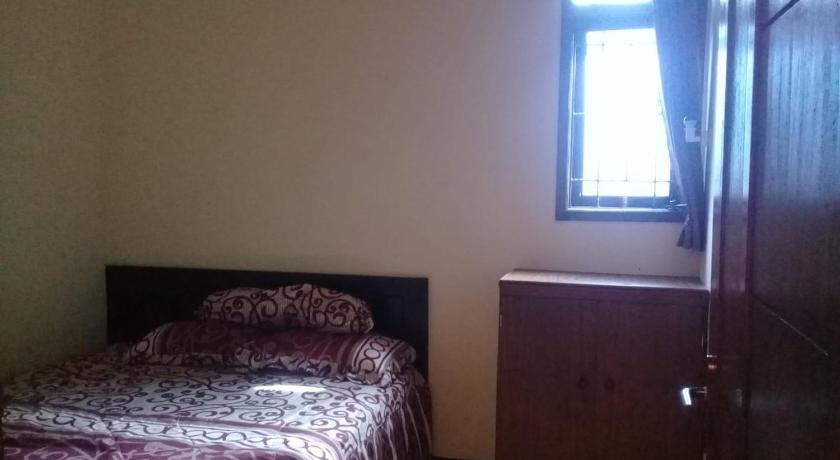 a bedroom with a bed and a window, Azalea Homestay in Malang