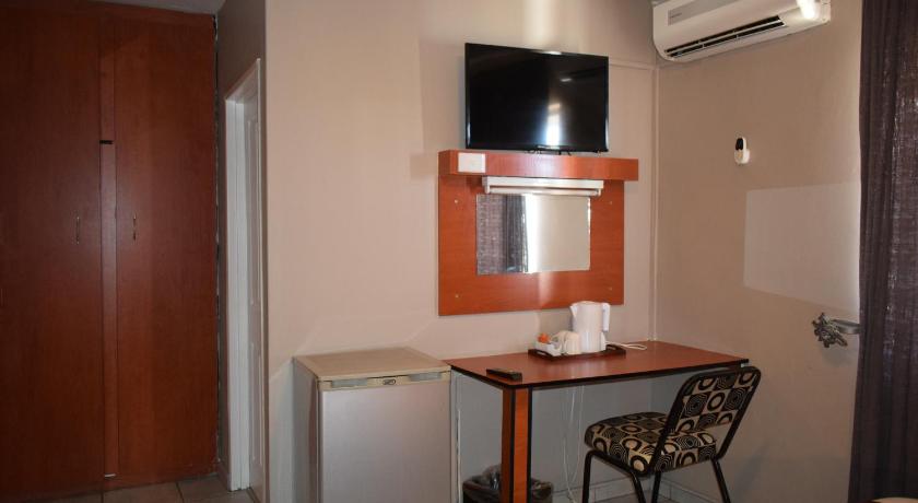 a kitchen with a table and a microwave, Scenery Guesthouse in Maseru