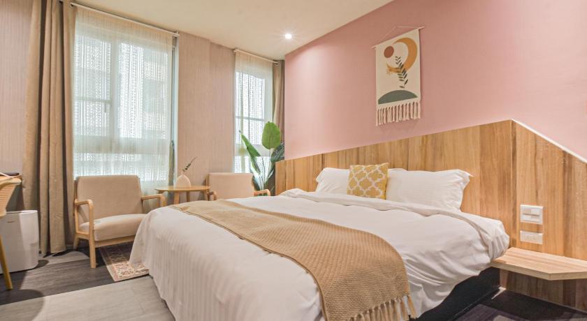 a hotel room with a bed, chair, and nightstand, Ashare Hotel in Yilan