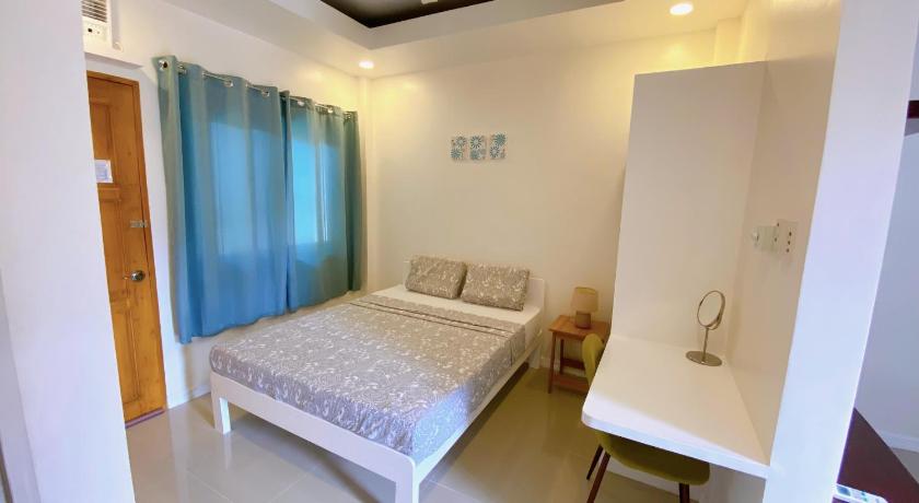 a bed room with a white bedspread and a white wall, Villa del OZ Resort in Bohol