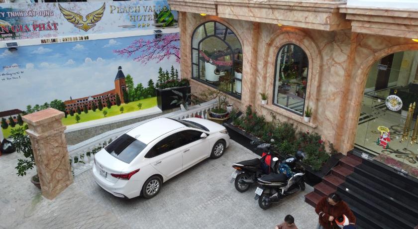 a car parked in front of a building next to a building, Peach Valley Hotel in Dalat