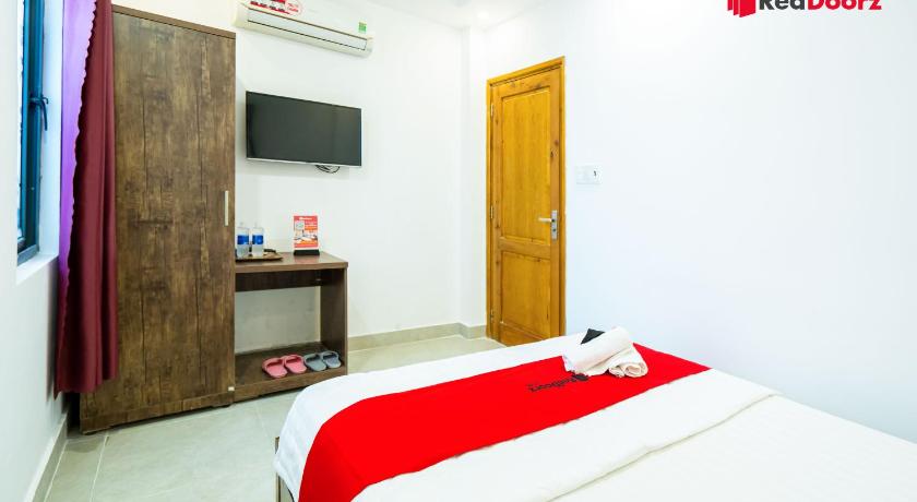 a bedroom with a bed and a dresser, RedDoorz The Sun Hotel near Duong Quang Ham Street in Ho Chi Minh City
