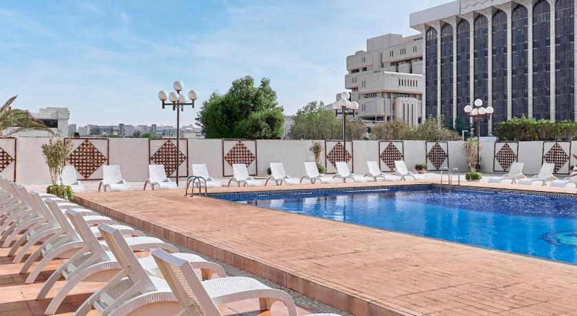 a large swimming pool in front of a large building, Crowne Plaza Riyadh Palace in Riyadh