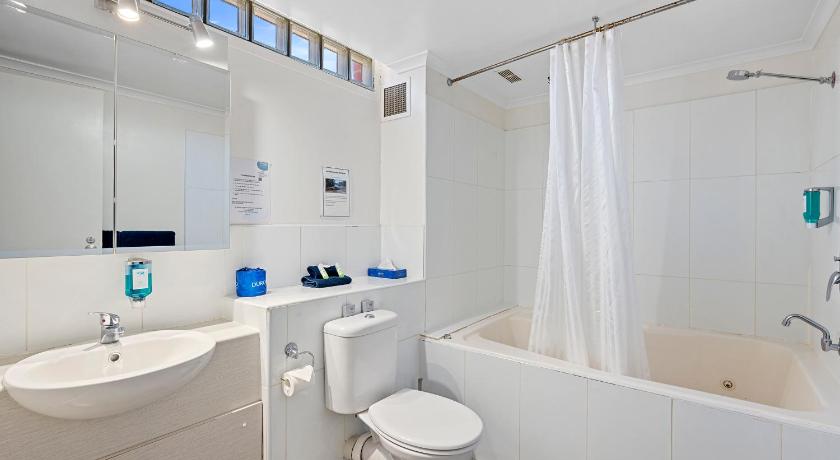 a bathroom with a tub, toilet, sink and shower, MAS Country  Riverboat Lodge Motor Inn in Echuca