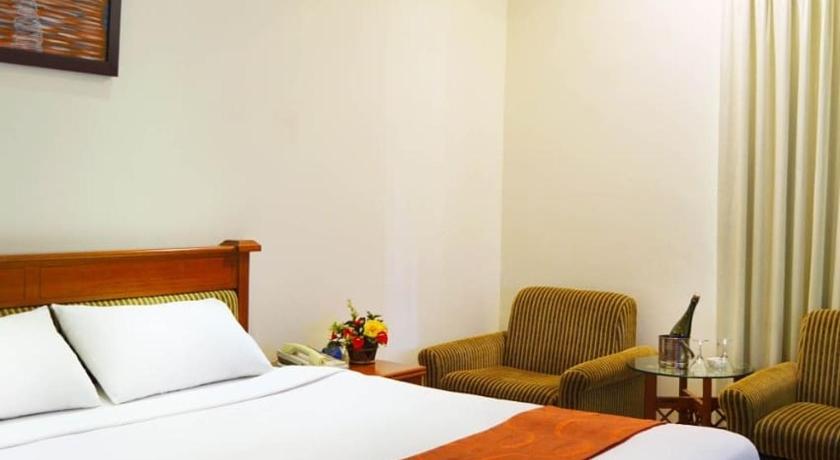 a hotel room with two beds and a television, Sanghyang Indah Spa resort in Anyer