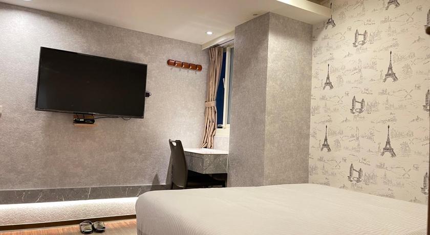 a hotel room with a bed and a television, Jung Shin Hotel in Taoyuan