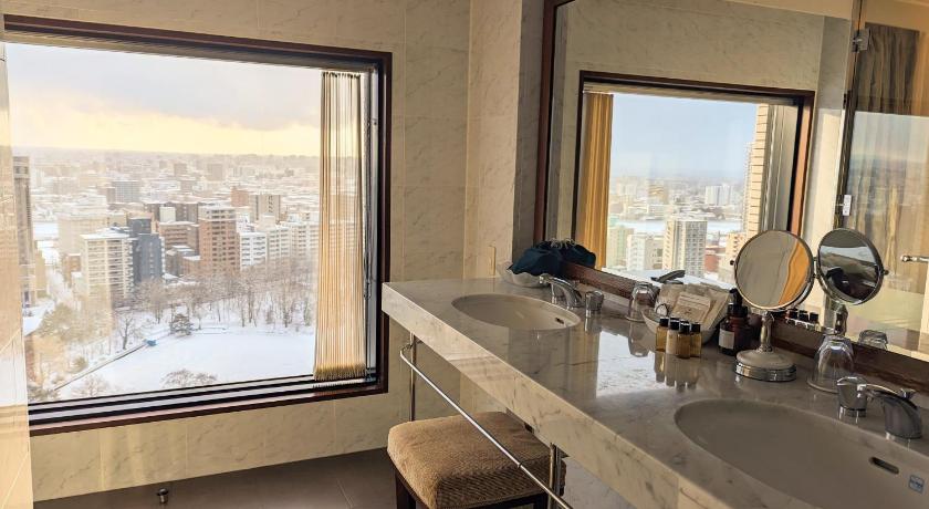 a bathroom with a tub, sink and mirror, Premier Hotel Nakajima Park Sapporo in Sapporo
